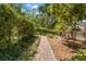 Lush garden path with brick pavers meandering through mature plantings, offering a tranquil retreat at 1001 E Crawford St, Tampa, FL 33604