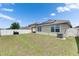 View of the backyard with green grass, white fence, solar panels, and an air conditioning unit at 10626 Park Meadowbrooke Dr, Riverview, FL 33578