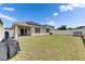 Backyard featuring grass, white fence, solar panels, an air conditioning unit, covered patio and a grill at 10626 Park Meadowbrooke Dr, Riverview, FL 33578