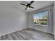 Cozy bedroom featuring a ceiling fan, wood-look floors and a bright window at 10626 Park Meadowbrooke Dr, Riverview, FL 33578