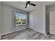 Cozy bedroom featuring a ceiling fan, wood-look floors and a bright window at 10626 Park Meadowbrooke Dr, Riverview, FL 33578