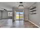 Open dining area with modern light fixture, slider doors to the backyard, and sleek wood floors at 10626 Park Meadowbrooke Dr, Riverview, FL 33578