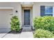Welcoming front door with charming landscaping and a modern exterior light fixture at 10626 Park Meadowbrooke Dr, Riverview, FL 33578