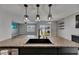 Kitchen island sink featuring granite countertops and views of the backyard and living room at 10626 Park Meadowbrooke Dr, Riverview, FL 33578