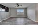 Inviting living room with sleek wood floors, a ceiling fan, and a wall-mounted TV at 10626 Park Meadowbrooke Dr, Riverview, FL 33578