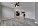 Open living space with gray wood floors connecting to modern kitchen with dark cabinets at 10626 Park Meadowbrooke Dr, Riverview, FL 33578