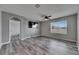 Open living room featuring stylish gray wood floors, a ceiling fan, and a large window for natural light at 10626 Park Meadowbrooke Dr, Riverview, FL 33578