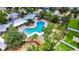 Aerial view of a community pool with lounge chairs, palm trees, and a covered seating area, perfect for relaxation and recreation at 10626 Park Meadowbrooke Dr, Riverview, FL 33578