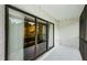 Screened balcony featuring sliding glass doors and textured walls, with ample space for outdoor seating at 1170 Pine Ridge W Cir # C2, Tarpon Springs, FL 34688