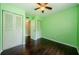 A bright bedroom features wood floors, dual closets, and a ceiling fan at 1170 Pine Ridge W Cir # C2, Tarpon Springs, FL 34688