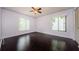Large bedroom with hardwood floors, ceiling fan and natural light from two bright windows at 1170 Pine Ridge W Cir # C2, Tarpon Springs, FL 34688