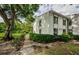 Exterior view of a condo building with a lush lawn and shade trees at 1170 Pine Ridge W Cir # C2, Tarpon Springs, FL 34688