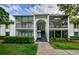 Inviting condo exterior featuring screened porches and lush landscaping, offering a blend of privacy and outdoor living at 1170 Pine Ridge W Cir # C2, Tarpon Springs, FL 34688