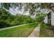 Walking path and lawn lead to property, surrounded by lush greenery at 1170 Pine Ridge W Cir # C2, Tarpon Springs, FL 34688