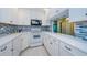 Updated kitchen featuring white cabinets, modern appliances, and a stylish blue backsplash at 1170 Pine Ridge W Cir # C2, Tarpon Springs, FL 34688