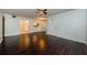 Spacious living room showcasing hardwood floors, ceiling fan, and seamless flow to the kitchen at 1170 Pine Ridge W Cir # C2, Tarpon Springs, FL 34688