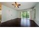 Bright living room with hardwood floors, ceiling fan, and a sliding glass door leading to the balcony at 1170 Pine Ridge W Cir # C2, Tarpon Springs, FL 34688
