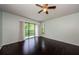 Bright main bedroom featuring hardwood floors, ceiling fan, and access to a screened balcony with scenic views at 1170 Pine Ridge W Cir # C2, Tarpon Springs, FL 34688