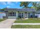 Inviting single-story home with stone accents, a well-manicured lawn, and a welcoming front entrance at 12250 Mallory Dr, Largo, FL 33774