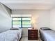 Bright bedroom featuring two twin beds with soft gray bedding and a window view at 14130 Rosemary Ln # 3215, Largo, FL 33774