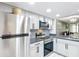 A view of the kitchen with stainless steel appliances, granite countertops and light grey cabinets at 14130 Rosemary Ln # 3215, Largo, FL 33774