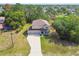 Aerial view of a charming two-story home with a long driveway, and surrounded by trees at 14282 Coronado Dr, Spring Hill, FL 34609