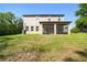 View of the back of the home from the spacious backyard, including a screened-in patio at 14282 Coronado Dr, Spring Hill, FL 34609