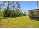 Lush backyard with green grass, mature trees and the rear of the home with screened porch visible at 14282 Coronado Dr, Spring Hill, FL 34609