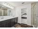 Bathroom featuring a double sink vanity with modern fixtures, wood-look floors, and an open doorway to the main bedroom at 14282 Coronado Dr, Spring Hill, FL 34609