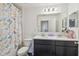 Bathroom showcasing a double sink vanity, toilet, and bathtub with a colorful butterfly-themed shower curtain at 14282 Coronado Dr, Spring Hill, FL 34609