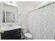 Standard bathroom showcasing a vanity, toilet, and bathtub with a patterned shower curtain, all under bright lighting at 14282 Coronado Dr, Spring Hill, FL 34609