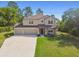 Charming two-story home with a three-car garage, landscaped yard, and covered front porch at 14282 Coronado Dr, Spring Hill, FL 34609