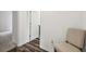 Hallway with wood-look floors leading to a doorway, complemented by a simple chair against a white wall at 14282 Coronado Dr, Spring Hill, FL 34609