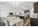 Open floorplan with dining table, dark kitchen island, stainless steel appliances, and a living area at 14282 Coronado Dr, Spring Hill, FL 34609