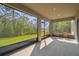 Inviting screened porch with seating, offering a serene view of the lush green backyard at 14282 Coronado Dr, Spring Hill, FL 34609