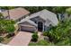 Aerial view of a well-maintained home showcasing a brick driveway, lush landscaping, and a neutral roof at 16219 Nottingham Park Way, Tampa, FL 33647