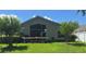 Exterior view of the back of the house with a lawn and screened-in patio at 16219 Nottingham Park Way, Tampa, FL 33647