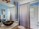 Stylish blue bathroom features modern fixtures, shower with gray curtain, and ample lighting at 16219 Nottingham Park Way, Tampa, FL 33647