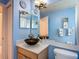 Stylish bathroom features modern vanity, vessel sink, and coordinated fixtures against blue walls at 16219 Nottingham Park Way, Tampa, FL 33647