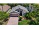 Inviting single-Gathering home featuring a brick driveway, mature landscaping, and a well-manicured lawn at 16219 Nottingham Park Way, Tampa, FL 33647