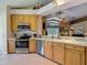 Bright kitchen featuring stainless steel appliances, light wood cabinets, and an open layout at 16219 Nottingham Park Way, Tampa, FL 33647