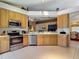 Bright kitchen featuring stainless steel appliances, light wood cabinets, and an open layout at 16219 Nottingham Park Way, Tampa, FL 33647