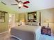 Relaxing main bedroom boasts a cozy king bed, mirrored accent wall, and ceiling fan at 16219 Nottingham Park Way, Tampa, FL 33647