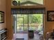 View of a screened porch, complete with seating, grill, and lovely views of the backyard at 16219 Nottingham Park Way, Tampa, FL 33647