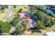 Aerial view of tennis courts surrounded by trees near a road and buildings in the neighborhood at 1908 Canterbury Ln # 28, Sun City Center, FL 33573
