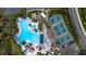 A scenic aerial view showcasing a community pool, spa, tennis courts, and outdoor seating areas at 1908 Canterbury Ln # 28, Sun City Center, FL 33573