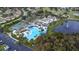 Aerial view of community amenities, including a pool, clubhouse, tennis courts, and pond at 1908 Canterbury Ln # 28, Sun City Center, FL 33573