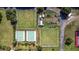 An aerial view displays bowling lawns, tennis courts, and a parking lot in a well-kept community at 1908 Canterbury Ln # 28, Sun City Center, FL 33573