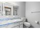 Bright bathroom featuring a sink with blue marbled counter, a toilet, and a mirror at 1908 Canterbury Ln # 28, Sun City Center, FL 33573