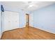 Bedroom featuring hardwood floors, blue walls, a ceiling fan, closet, and door to bath at 1908 Canterbury Ln # 28, Sun City Center, FL 33573
